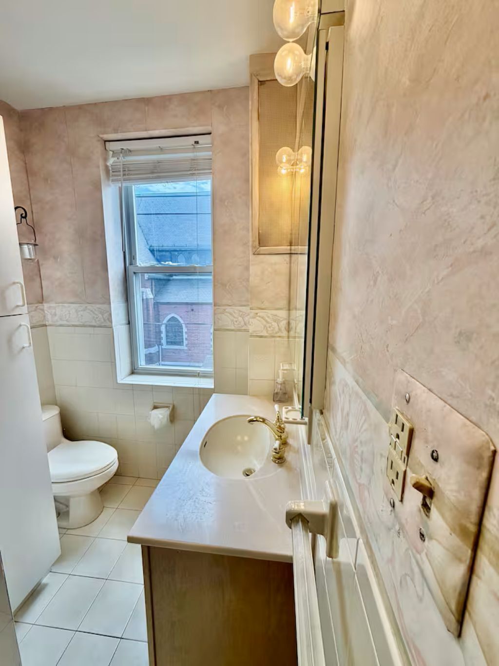 Ein Badezimmer mit Toilette, Waschbecken und Fenster.