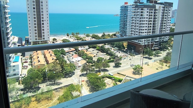 A high-rise building with a view of the ocean and a construction crane in the distance. - Vista al mar piscina y confort 7 pax (Santa Marta)