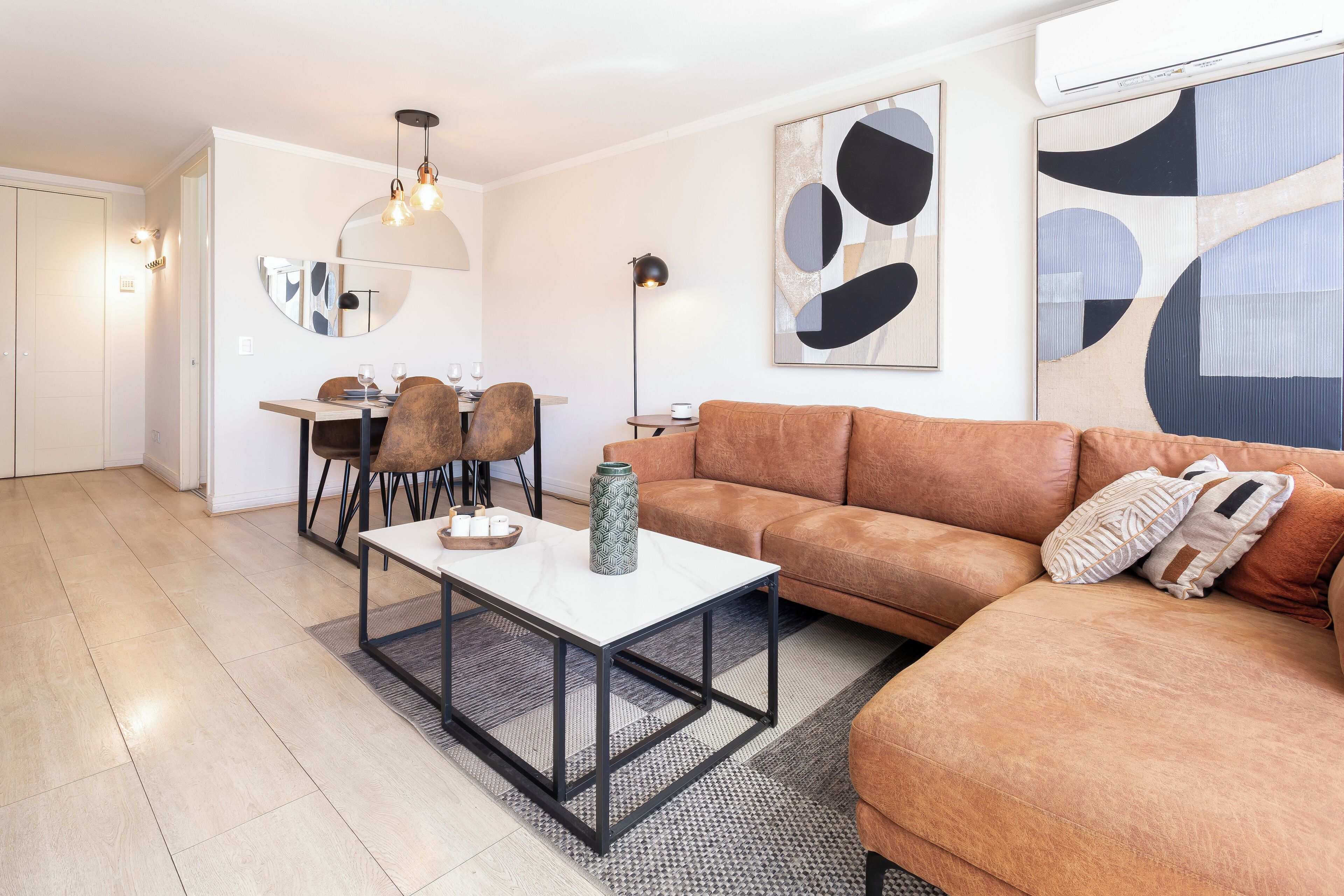 A modern living room with a sofa, coffee table, and dining area.