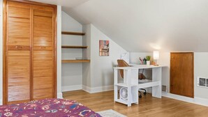 Ein Schlafzimmer mit Bett, Schreibtisch und Kleiderschrank.