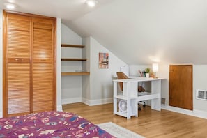 Ein Schlafzimmer mit Bett, Schreibtisch und Kleiderschrank.