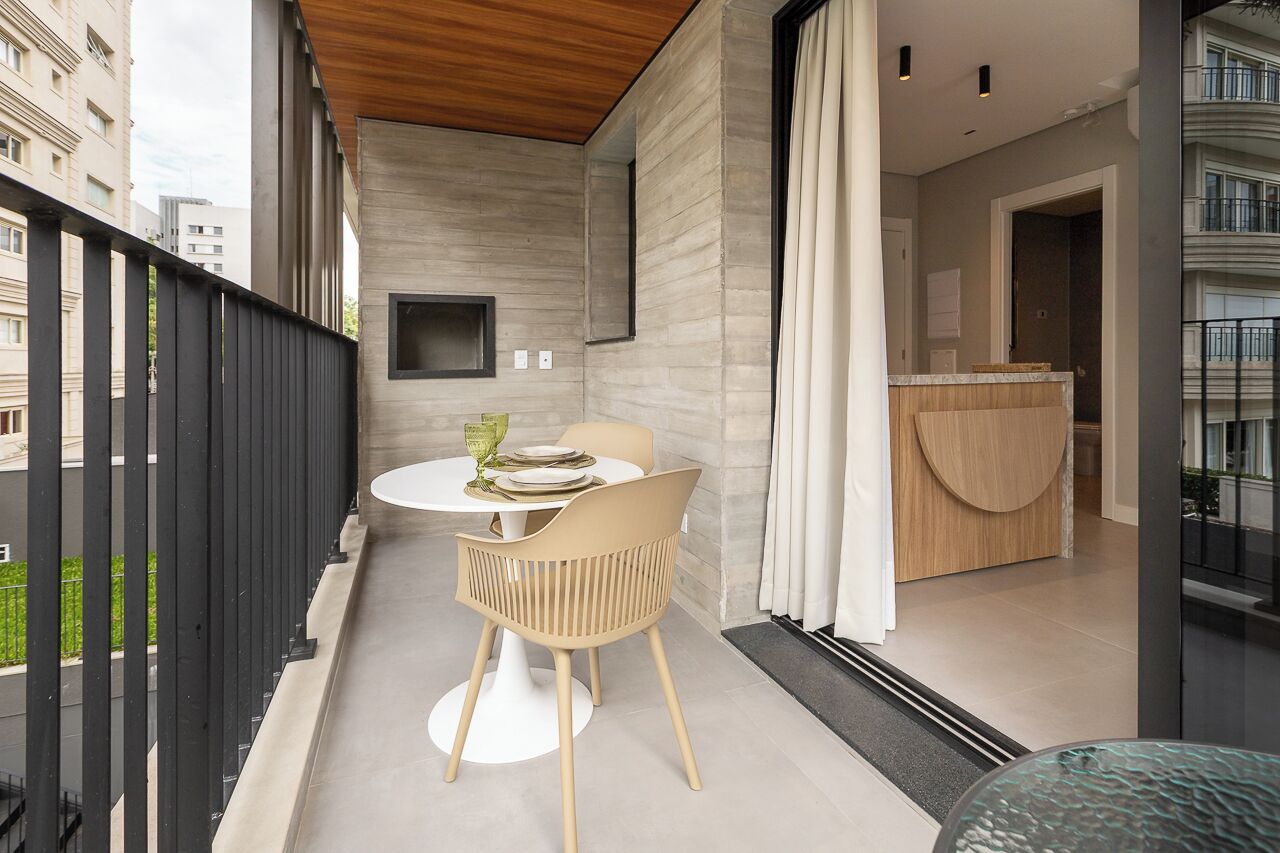 A balcony with a table and chairs, a wooden ceiling, and a view of a building.