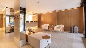 Uma sala de estar moderna com sofá, poltronas, uma mesa de centro e objetos decorativos.