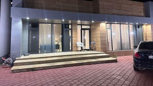 A modern building with a flat roof, large glass windows, and a set of steps leading to the entrance. - Villa warm pool (Баку)