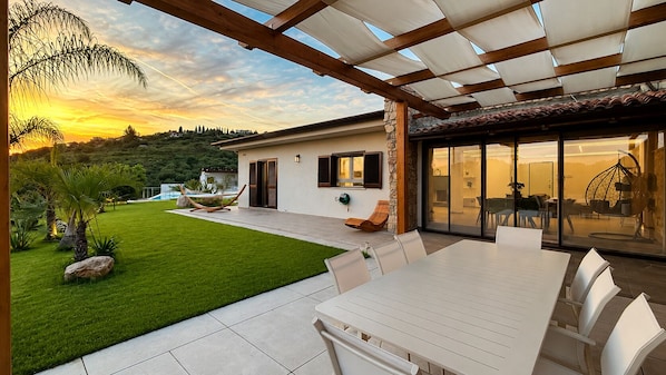 A modern house with a patio, a dining area, and a view of the countryside. - Villa Heaven Nature (Lazio)