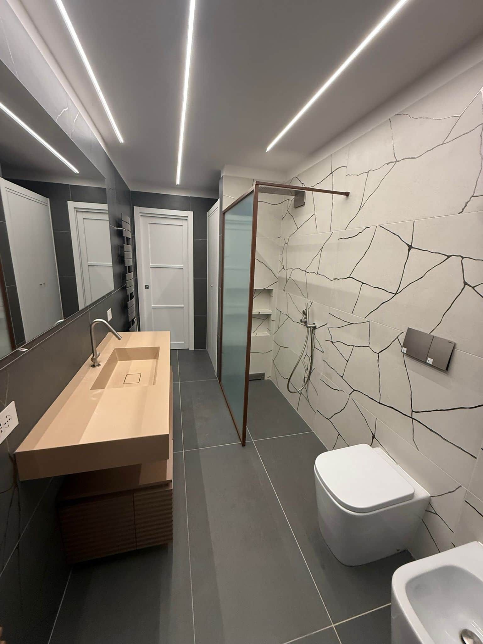 Une salle de bain moderne avec un grand lavabo, des toilettes et un espace douche.