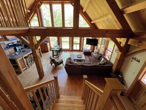 Ein Holzblockhaus mit Essbereich, Küche und einer großen Couch.