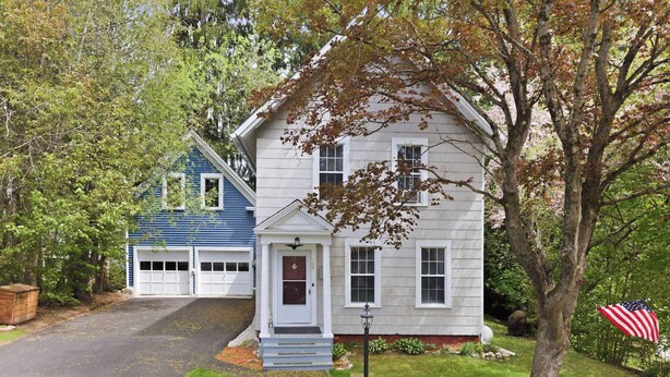 A two-story house with a front porch, a garage, and a tree with an American flag. - Historic Gem in the Heart of Littleton (Littleton)