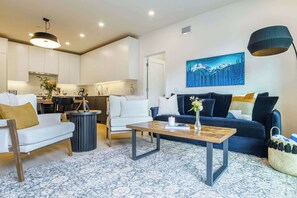 Ein modernes Wohnzimmer mit einer Couch, einem Couchtisch und einem Gemälde an der Wand.