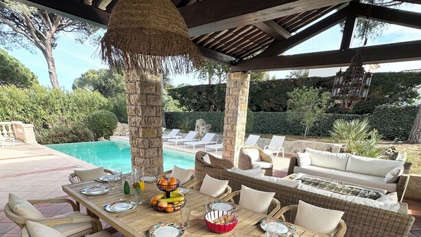 An outdoor dining area with a pool view, wicker furniture, and a thatched roof. - Villa Golf Esterel 150m2 quiet with swimming pool (Saint-Raphaël)