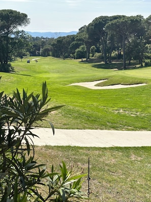 A golf course with sand bunkers, a clear sky, and distant mountains. - Villa Golf Esterel 150m2 quiet with swimming pool (Saint-Raphaël)