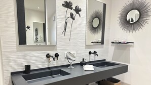 A modern bathroom with a double sink, a large mirror, and decorative wall art. - Villa Golf Esterel 150m2 quiet with swimming pool (Saint-Raphaël)