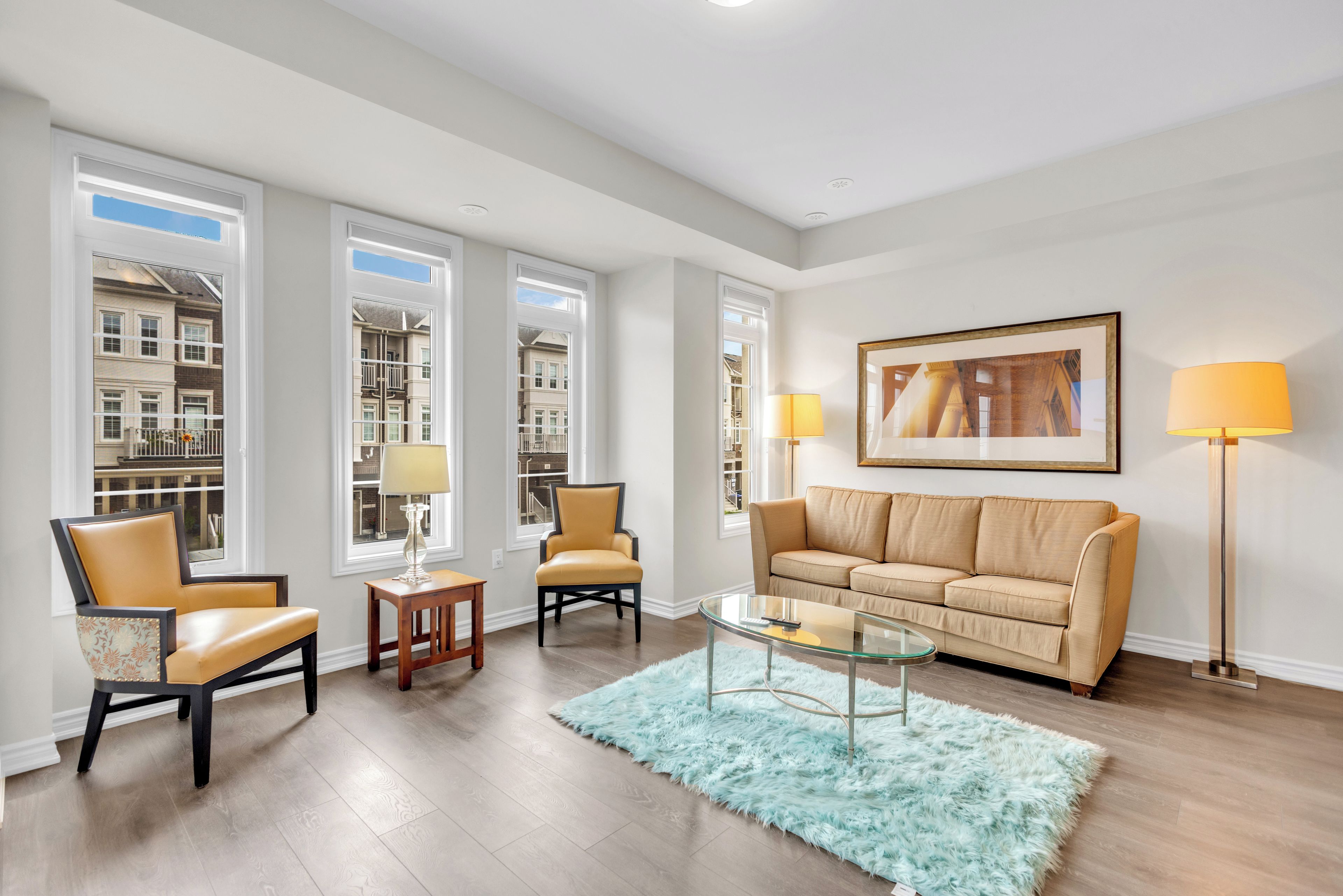 A living room with a sofa, chairs, a coffee table, and a rug.