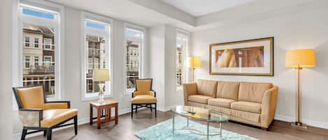 A living room with a sofa, chairs, a coffee table, and a rug.