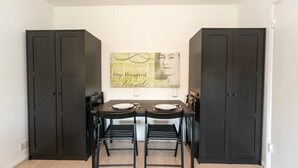 Een eethoek met een tafel, stoelen en een kunstwerk aan de muur.