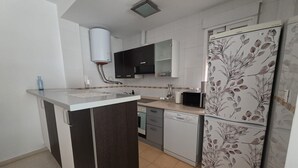 A kitchen with a central island, a microwave, a refrigerator, and a dishwasher. - Penthouse Castell de ferro (Castell de Ferro)