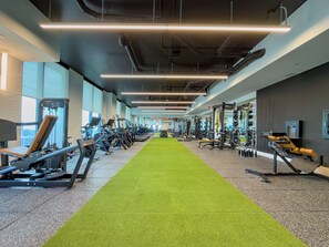 A gym with exercise equipment, a green carpet, and large windows. - F312B - Downtown Miami Cozy Studio with Pool & Gym (Miami)