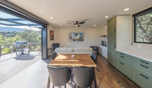 Eine moderne Küche mit Essbereich, Holzboden und Blick ins Freie.