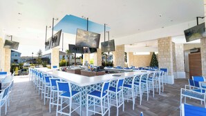 A spacious outdoor bar area with multiple seating arrangements and a central island. - Luxury Townhouse w/ Private Pool Near Clubhouse (Davenport)
