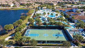 A residential area with a large swimming pool, tennis courts, and a lake. - Windsor Westside Resort Townhouse w/ Pool & Fast Wifi (Kissimmee)