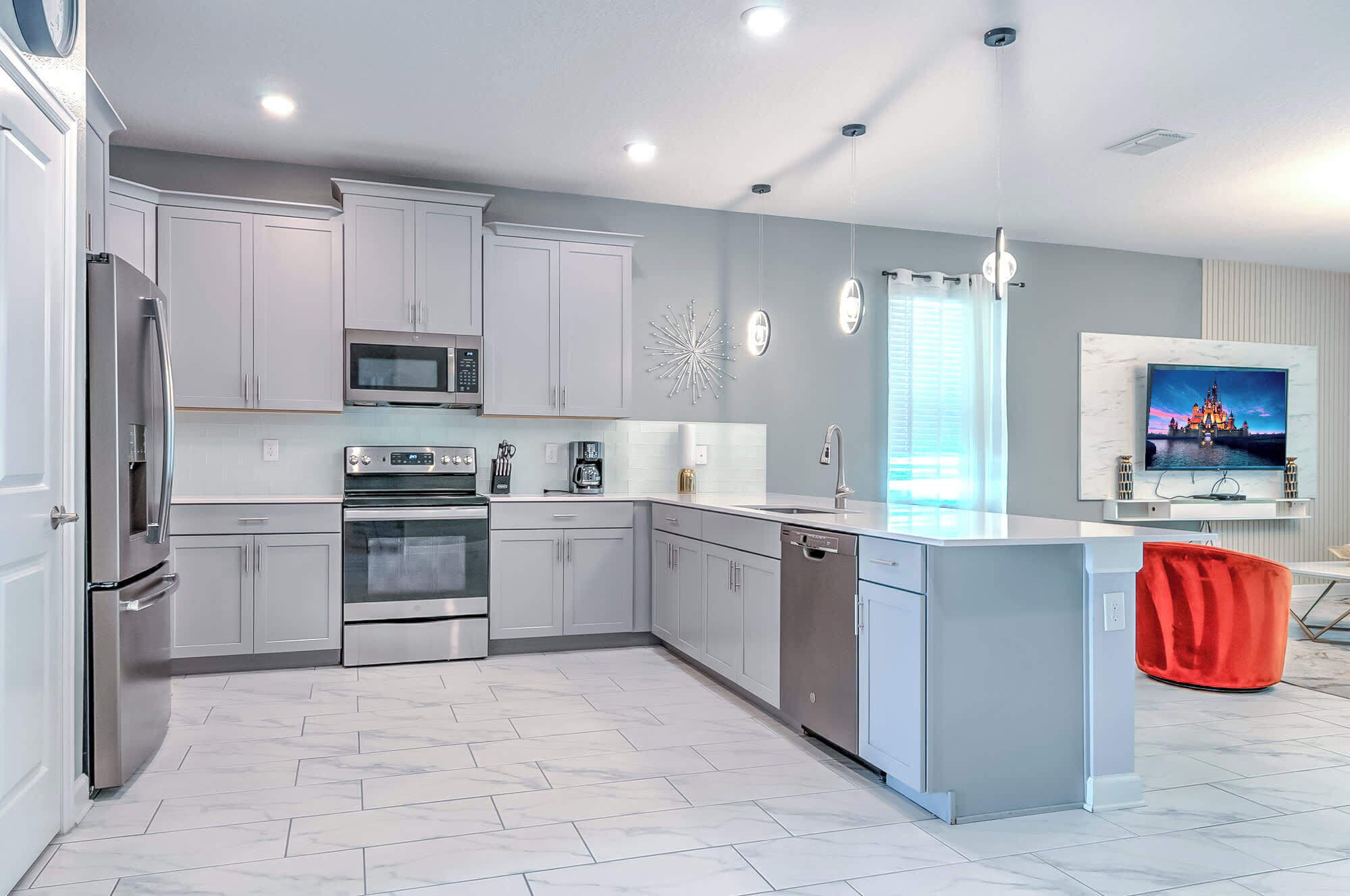 A modern kitchen with stainless steel appliances, a dishwasher, and a large island.