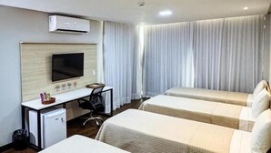 A hotel room with two beds, a desk, a chair, a television, and a window with curtains. - Citi Executivo Hotel (Parnaíba)