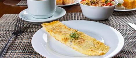 A breakfast setting with an omelette, coffee, and various side dishes on a table.