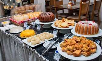 A buffet with various food items including bread, cakes, and pastries.