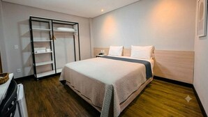 A bedroom with a bed, a wardrobe, and a nightstand.
