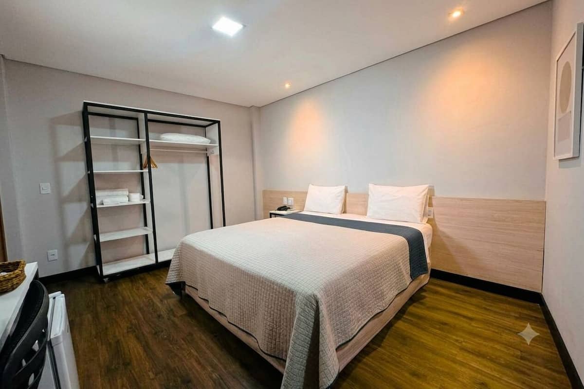 A bedroom with a bed, a wardrobe, and a nightstand.