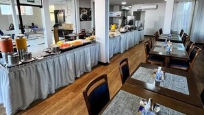 A dining area with tables, chairs, and a buffet setup.