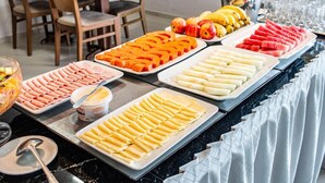A buffet with various food items including sliced fruits, vegetables, and pasta. - Citi Executivo Hotel (Parnaíba)