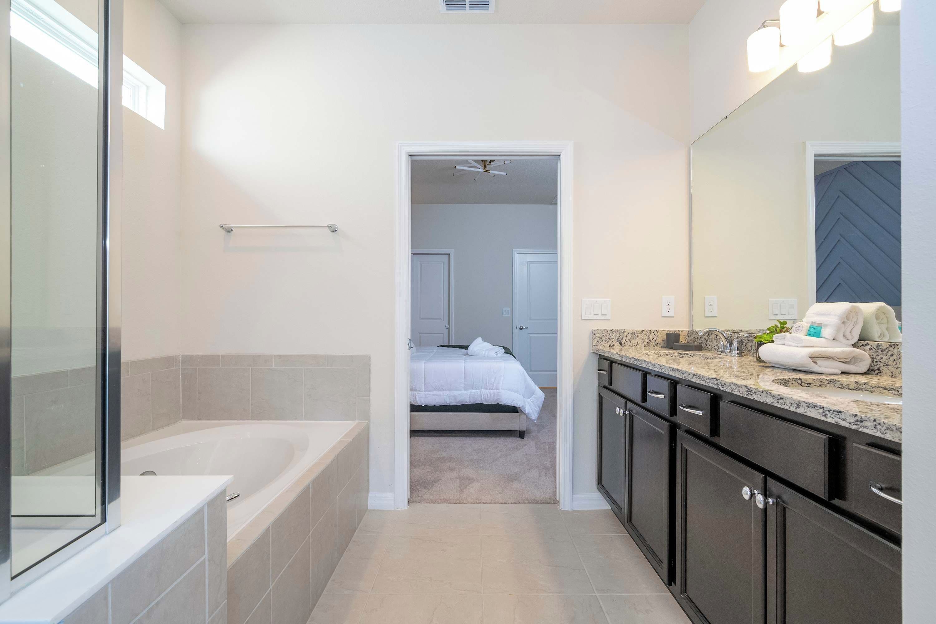 Een moderne badkamer met een bad, een wastafel met spiegel en een douche.