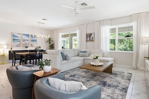 Ein modernes Wohnzimmer mit Sofa, Couchtisch und Essbereich.