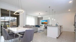 A modern apartment with a dining area, living room, and kitchen. - Modern Family Townhouse With Private Pool in Storey Lake (Kissimmee)