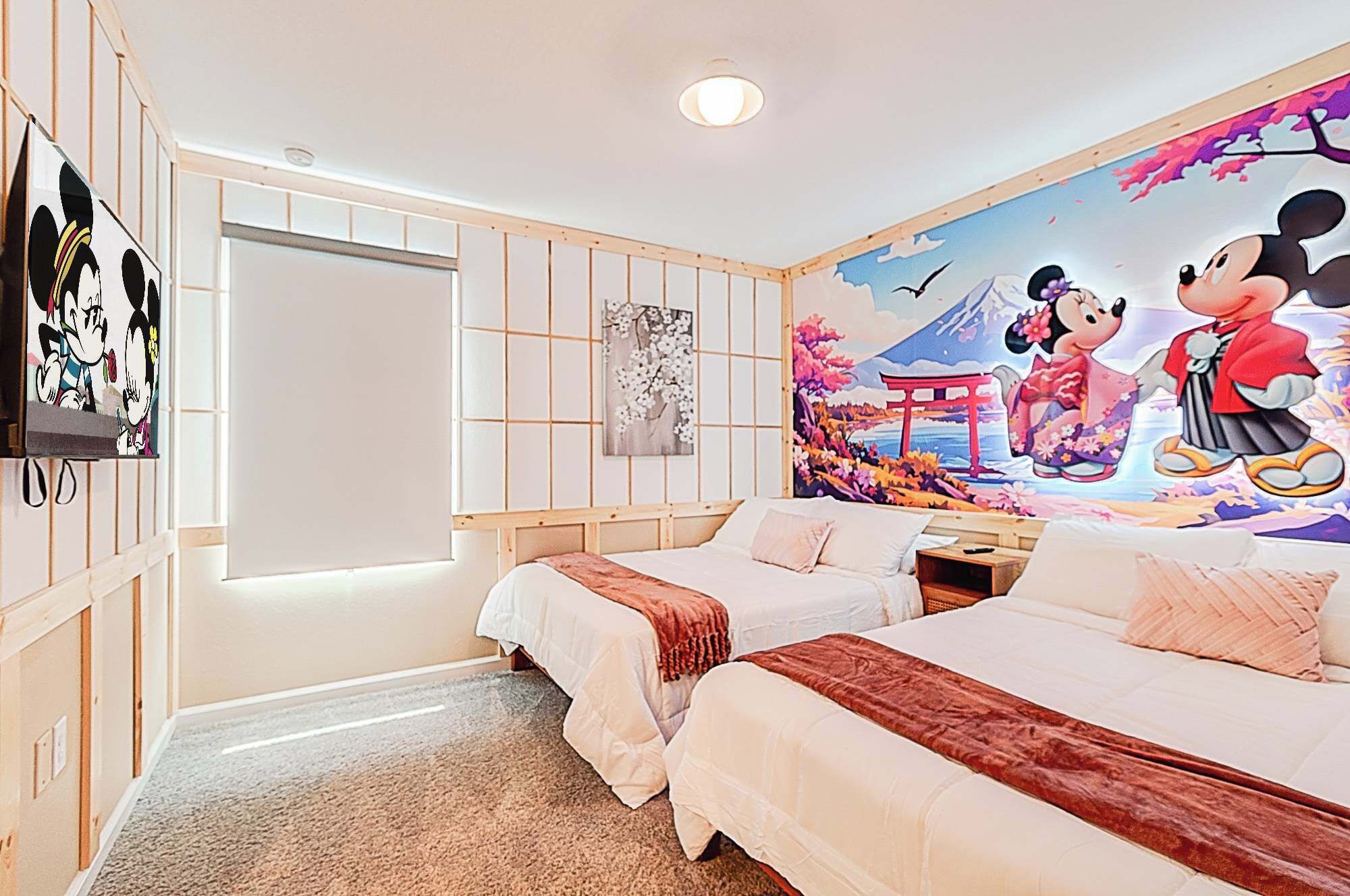 A hotel room with two beds, a large mural of Mickey and Minnie Mouse, and a traditional Japanese-style sliding door.
