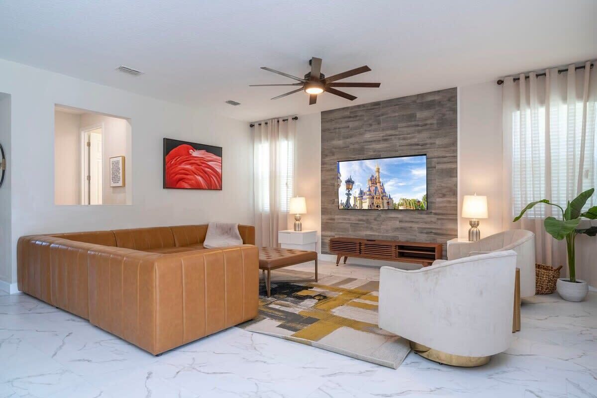 A modern living room with a sofa, armchair, TV, and decorative elements.