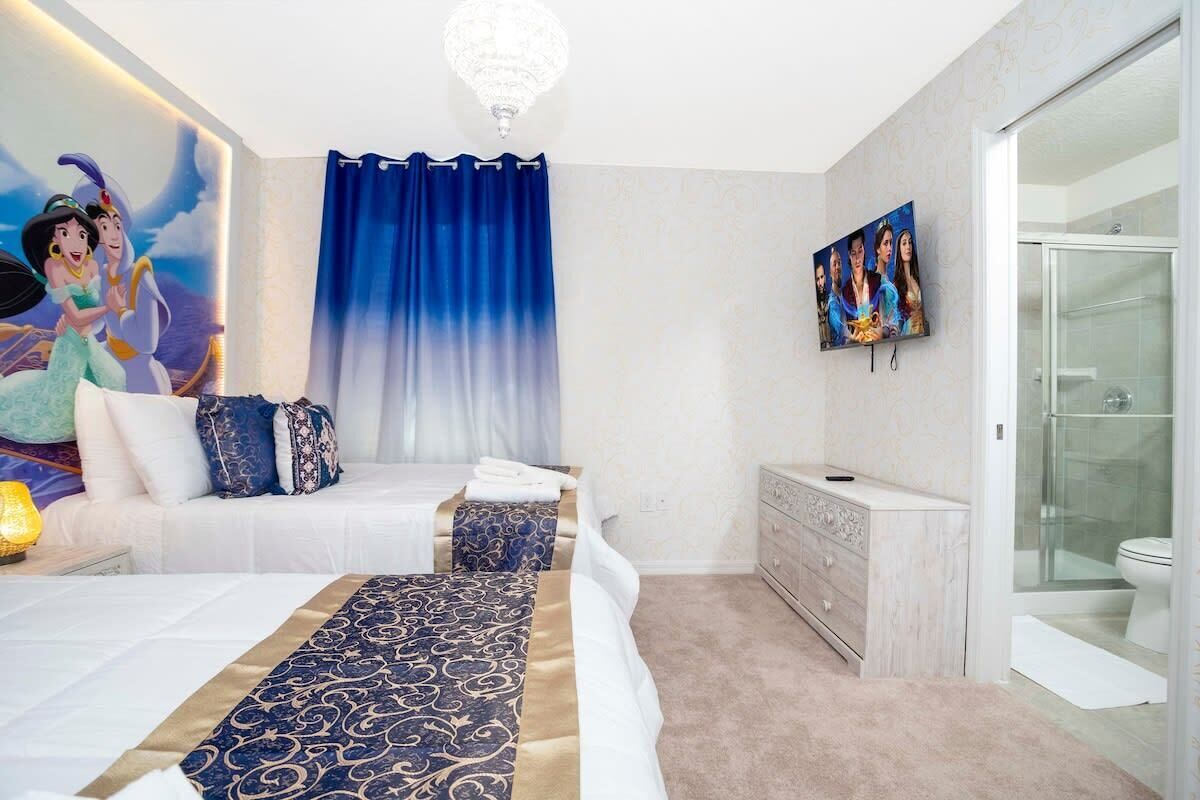 A hotel room with a large bed, a vanity with a mirror, a shower area, and a mural on the wall.
