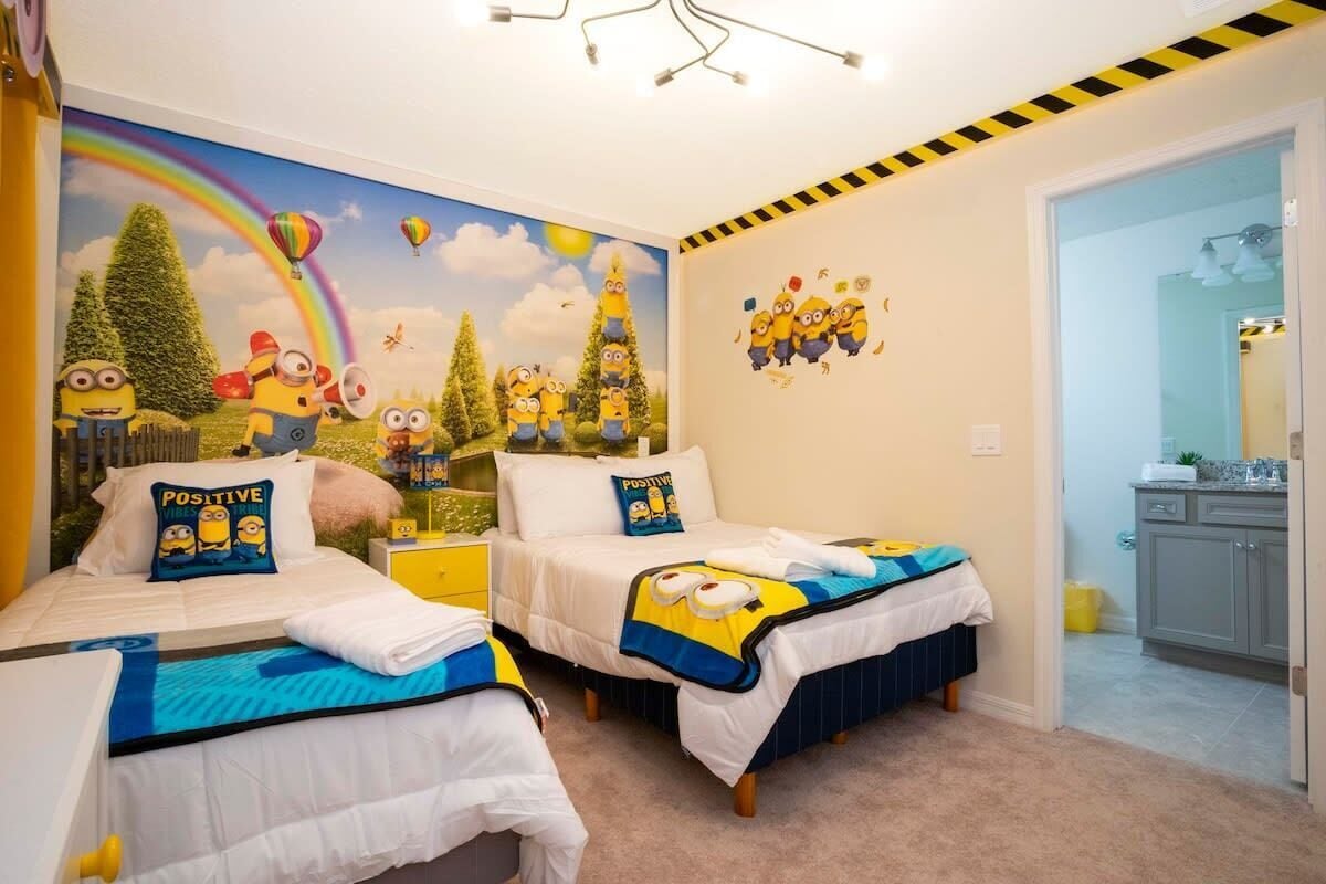 A bedroom with two beds, a mural, and a bathroom visible.