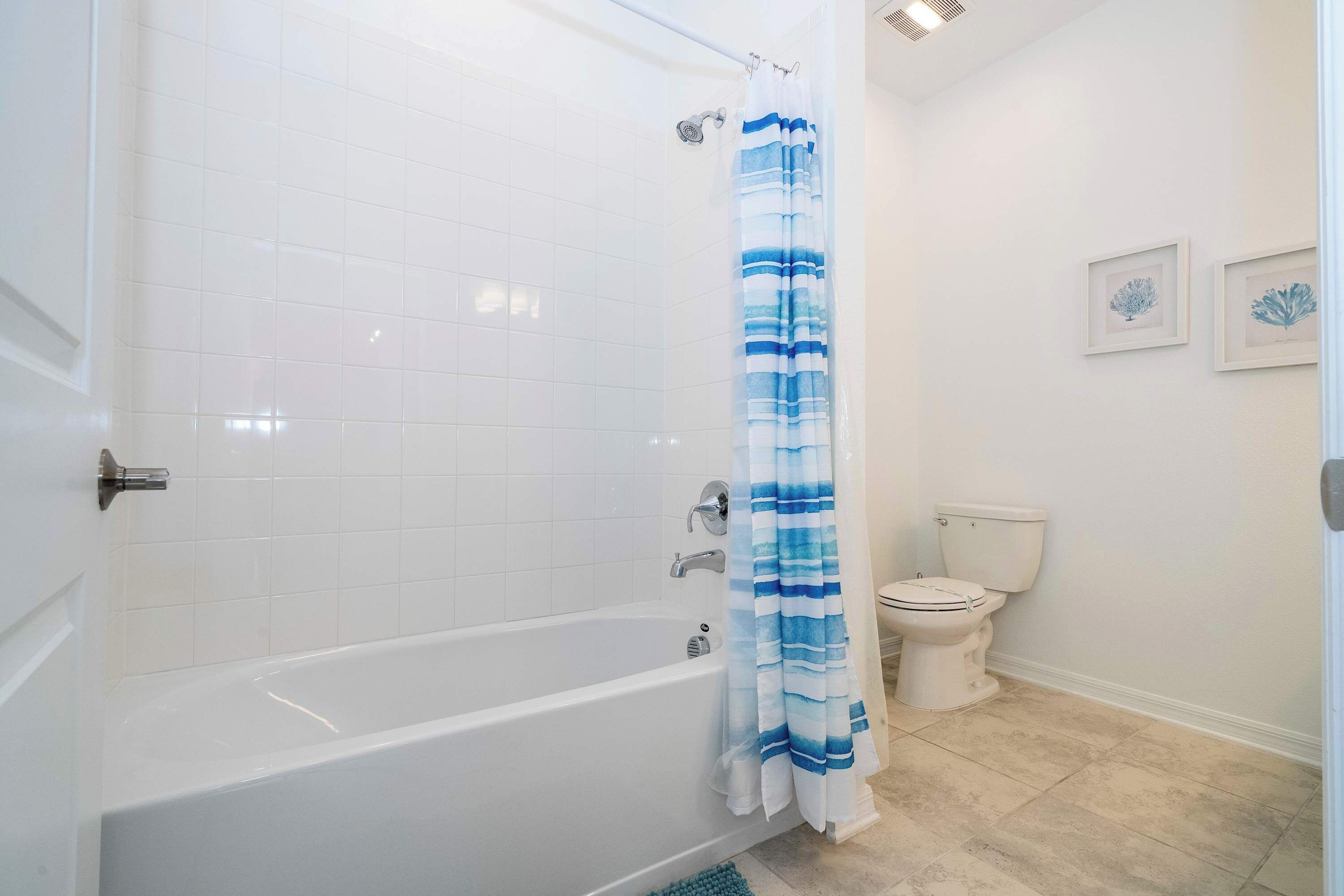 Un baño con bañera, inodoro y cortina de ducha.