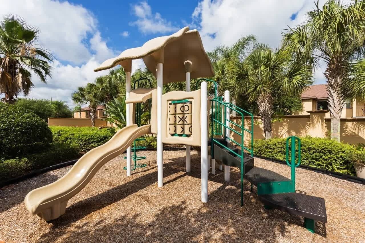 Ein Spielplatz mit Rutsche, Klettergerüsten und einem überdachten Spielbereich.