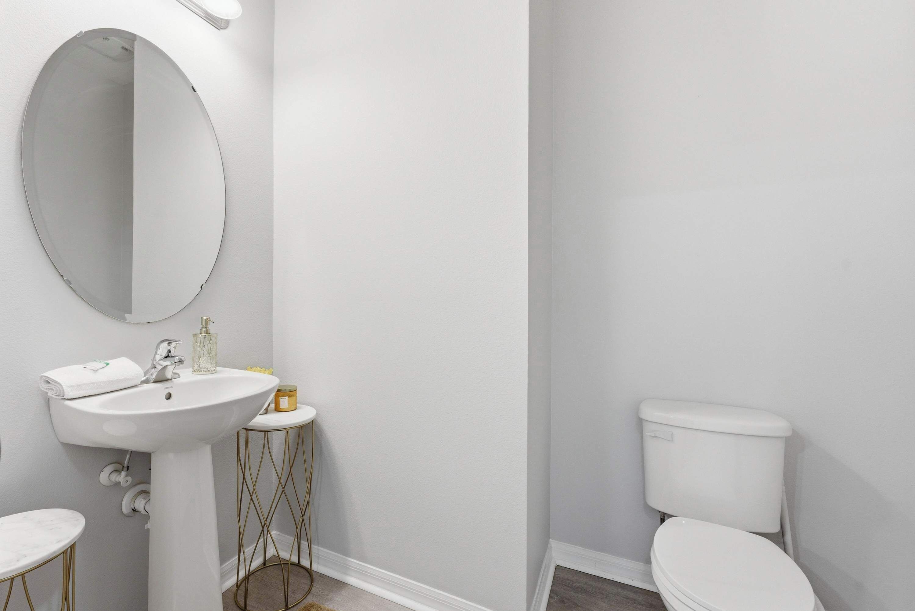 A bathroom with a white sink, mirror, and toilet.