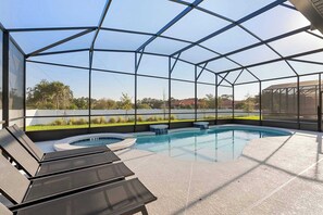 A covered outdoor swimming pool with lounge chairs and a hot tub. - Themed 10bd Family Home w/ Private Pool & Game Room (Orlando)
