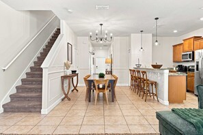 A spacious kitchen with a central island, wooden cabinets, and a built-in microwave. - Family-friendly Paradise Palms Townhouse With Pool Access (Kissimmee)