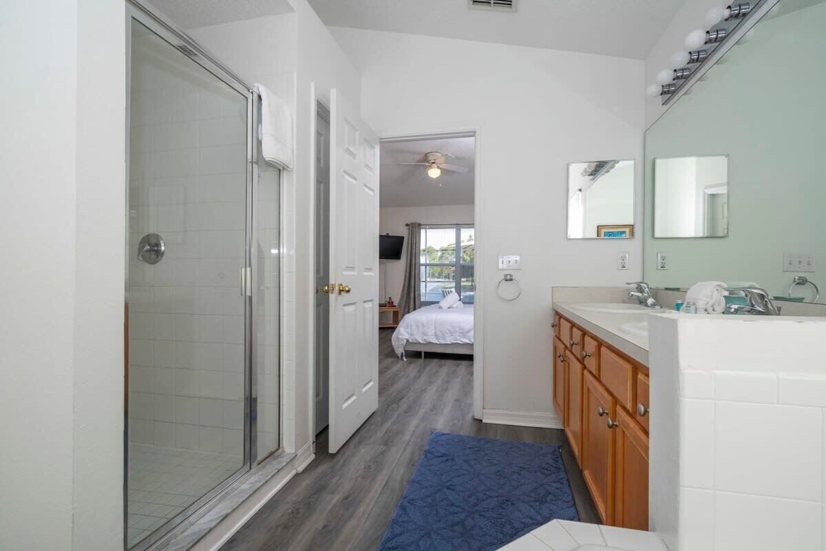 A bathroom with a shower, a sink, and a mirror.
