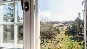Een uitzicht op een glooiend landschap met bomen en een heldere lucht.