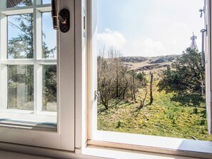 A window with a view of a hilly landscape with trees and a clear sky. - 5 Star Holiday Home in Fano (Fano)