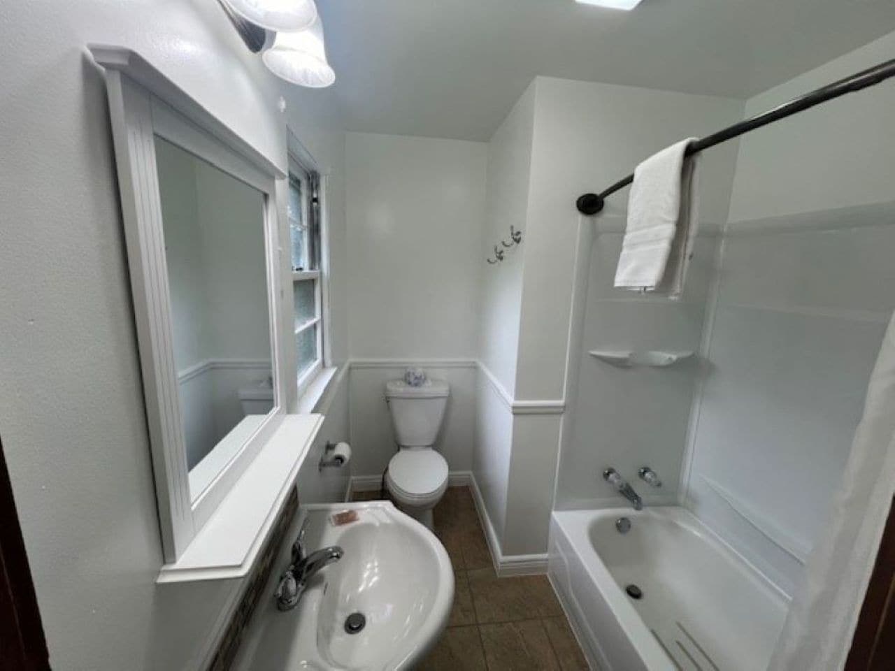 A compact bathroom with a sink, toilet, and bathtub.