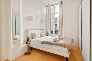 Ein Schlafzimmer mit einem Bett, einem Nachttisch und einem Spiegel.