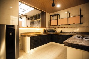 Eine moderne Küche mit Kühlschrank, Herd und Mikrowelle.